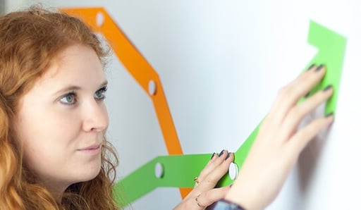 woman connecting lines on whiteboard